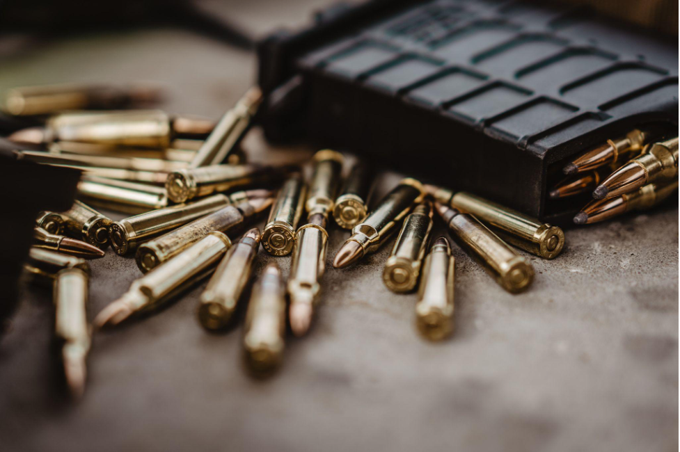 bullets scattered along with a magazine filled with bullets 