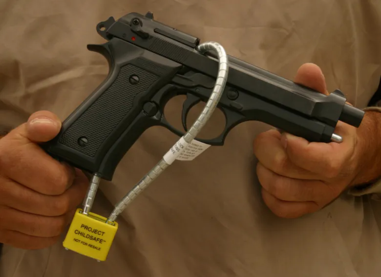 a man holding a child safe gun | firearms